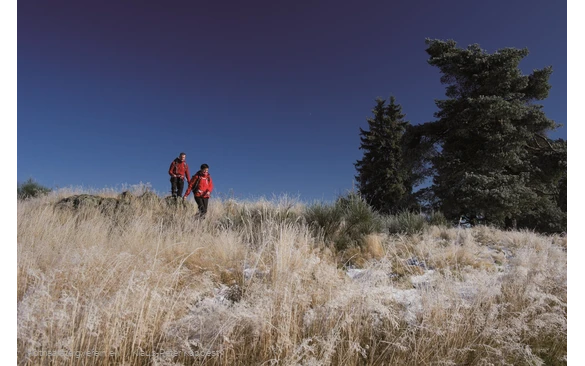 Zwei Rothaarsteig-Wanderer mit roten Jacken vor blauem Himmel
