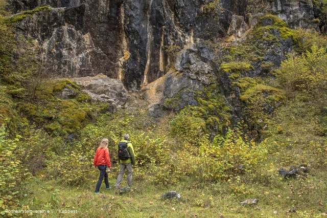 Zwei Wanderer vor einer Felswand
